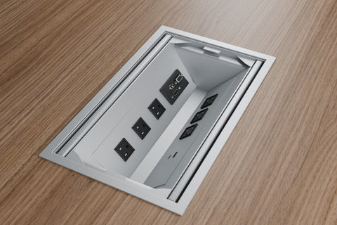 Long silver power grommet with 6 outlets, lid open in a wood laminate table top