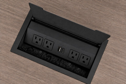 Black power grommet with 4 outlets and USB charging, lid open in a light brown woodgrain top