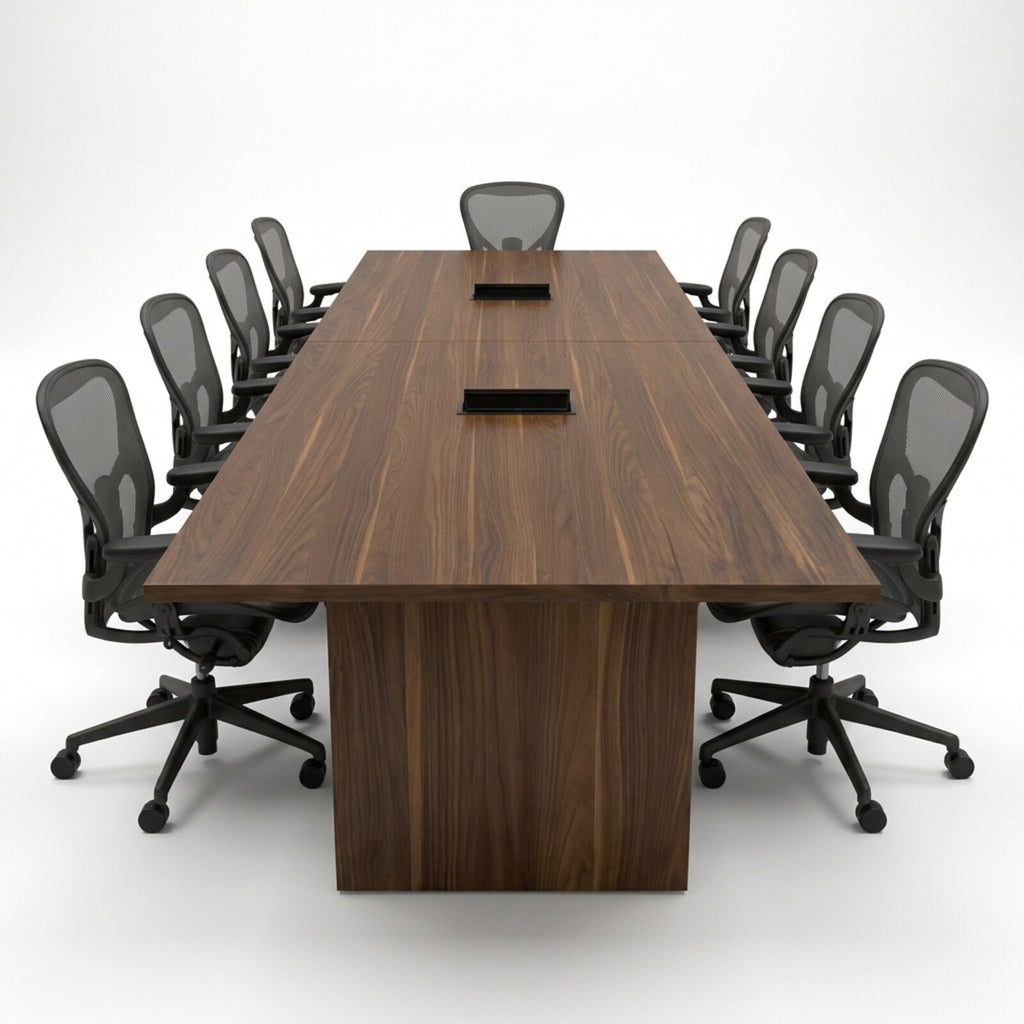 Head-on view of the walnut conference table with two recessed power grommets, a two-section top and dark gray mesh task chairs