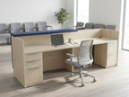 Light woodgrain reception desk with navy counter in a medical clinic waiting room