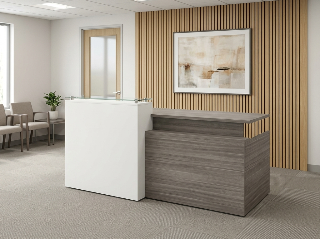 Gray and white reception desk with glass counter facing a small waiting area