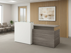 Gray and white reception desk with glass counter facing a small waiting area
