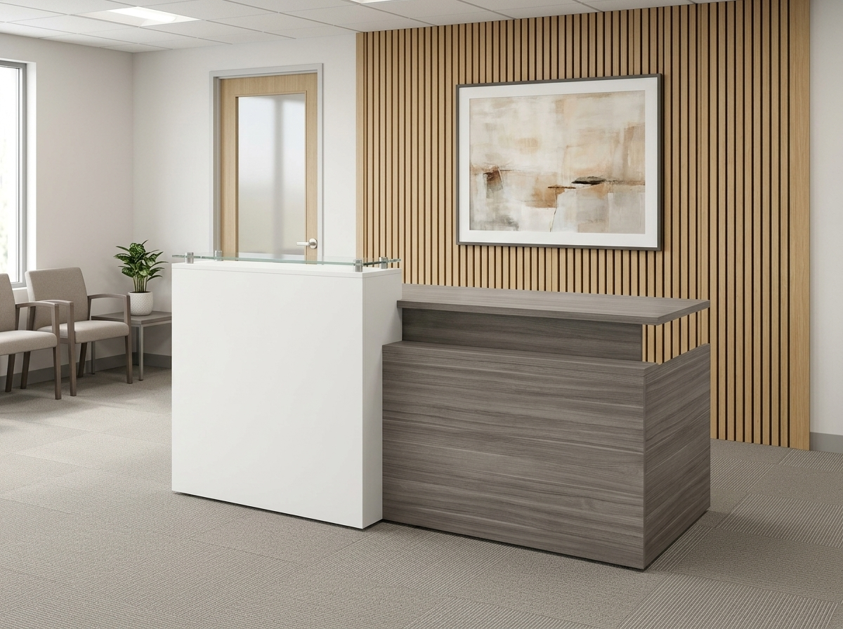 Gray and white reception desk with glass counter facing a small waiting area