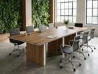 Walnut conference table with panel base in front of a living green wall