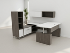 Full view of a dark gray U shaped office desk with tower and overheads, plant in the corner