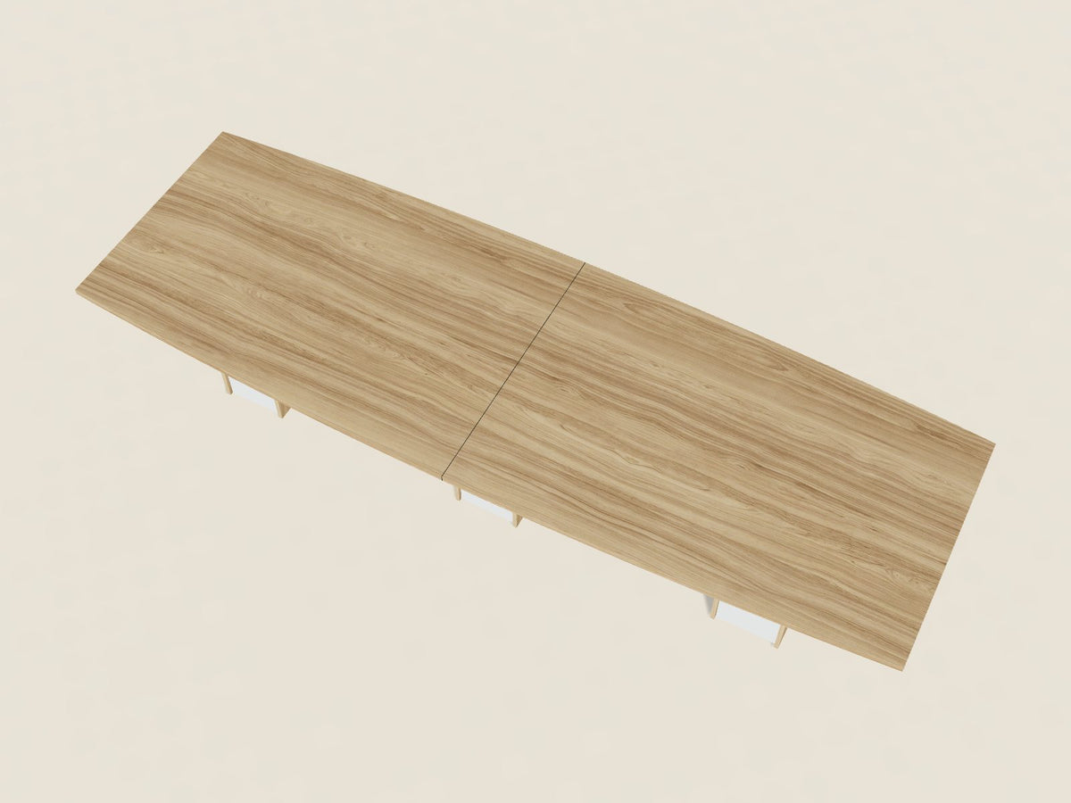 Boat shape conference table in Fawn Cypress, a light tan woodgrain laminate, seen from above, wider at the middle