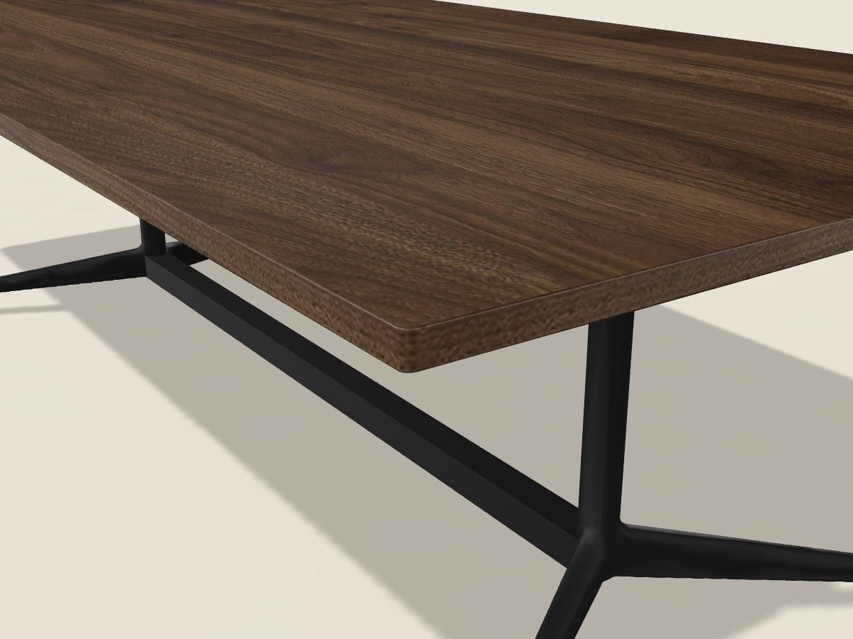 Close-up of the PVC edge on a California Walnut laminate conference table corner, black metal base below